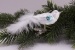 kleiner Vogel Eisweiß türkis mit weißer Feder